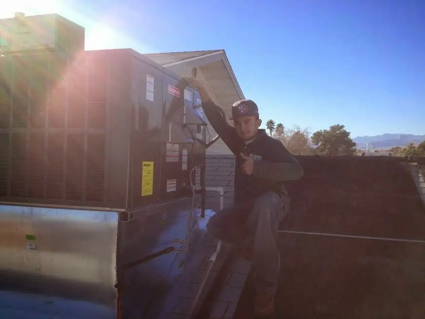 HVAC technician performing Heat Pump Repair on a rooftop unit in Lennox